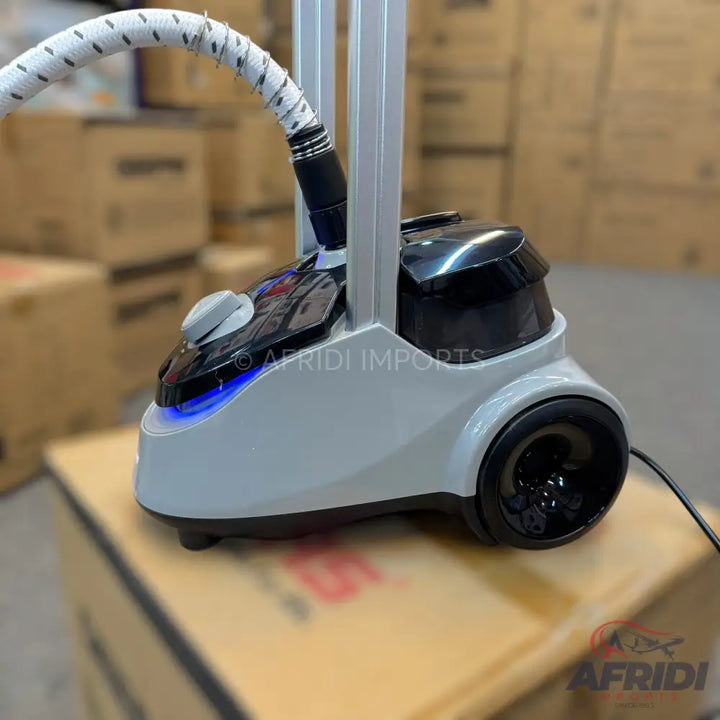 A floor-standing garment steamer with a white and black base, a flexible hose, and an adjustable pole.