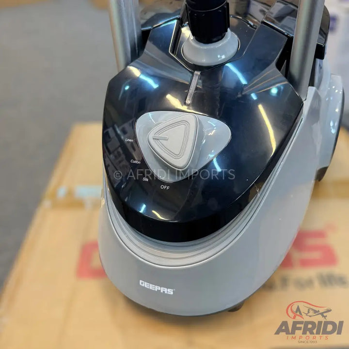 A grey and black garment steamer with a triangular control knob.