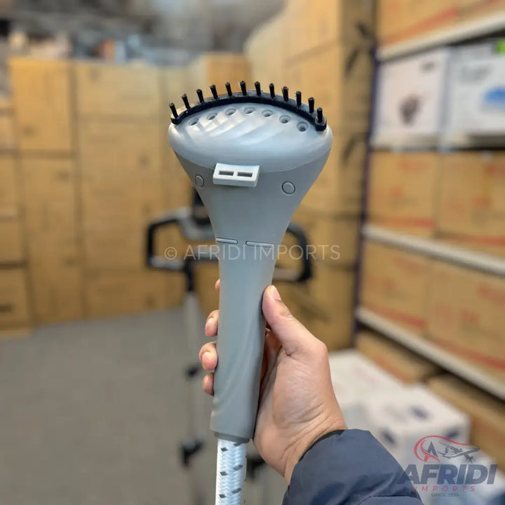 Handheld clothes steamer head with a brush attachment.