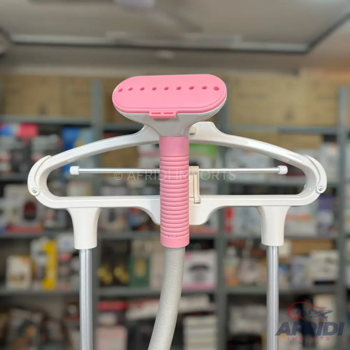 Pink and white vertical garment steamer with an integrated hanger.