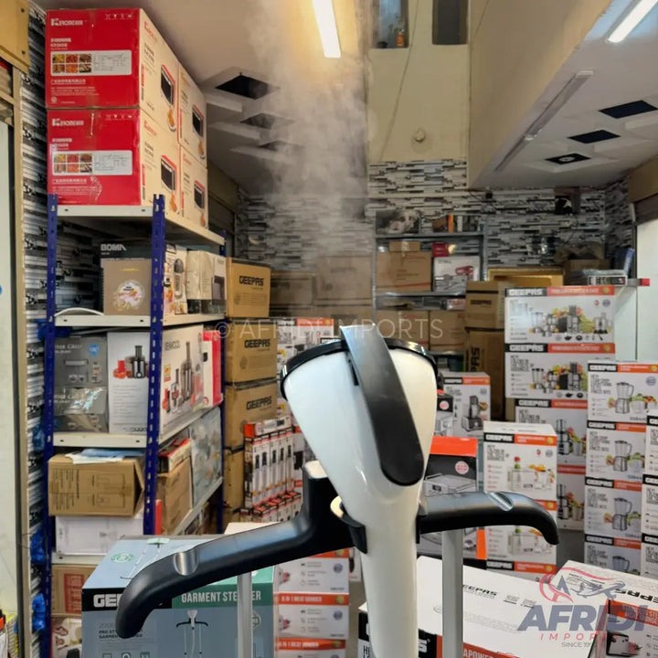 White and black garment steamer emitting steam.