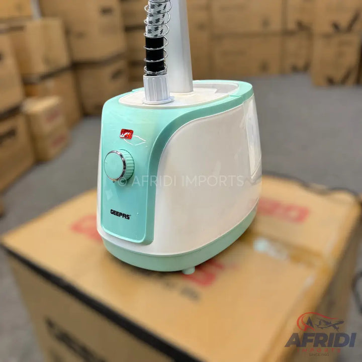 Mint green and white handheld garment steamer with a control knob.