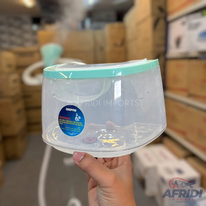 A clear plastic humidifier water tank with a light green rim.
