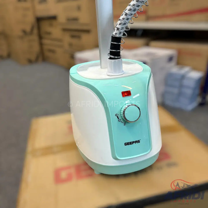 White and teal garment steamer with a flexible hose and control dial.