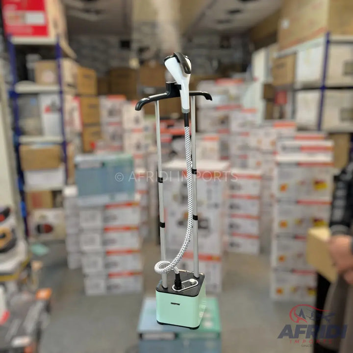Mint green and black garment steamer with a white and black steaming head, two adjustable poles, and a braided hose.