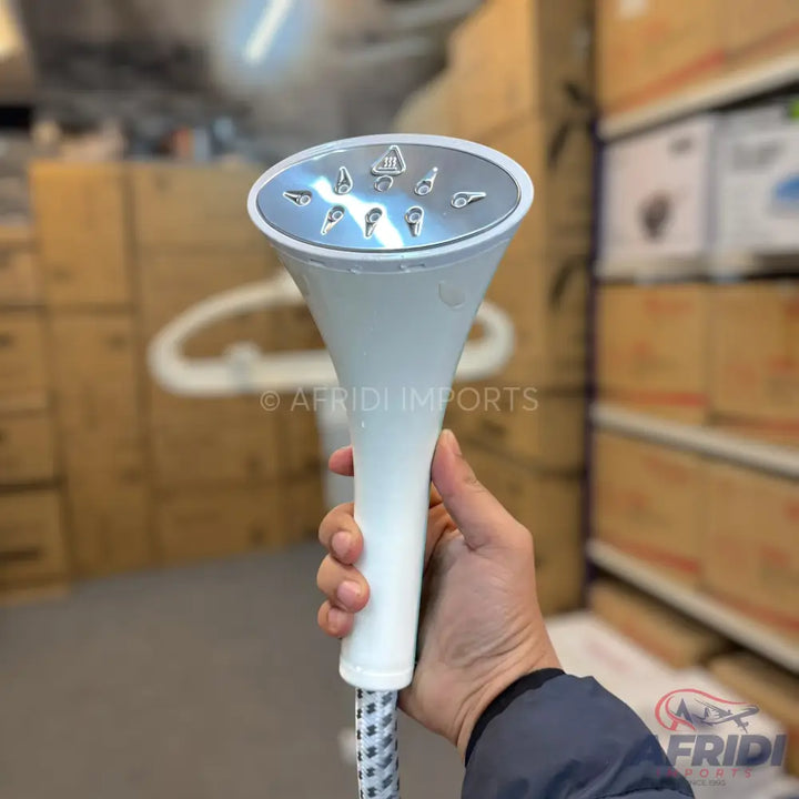 Handheld white garment steamer with a silver head and multiple steam vents.