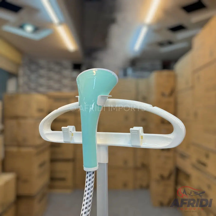 Standing garment steamer with a white hanger and a turquoise steaming head.