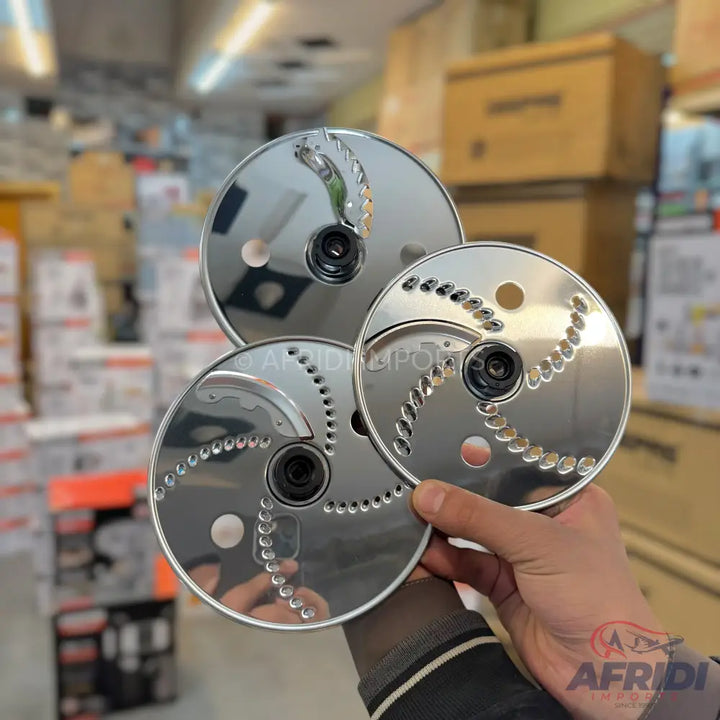 A set of three stainless steel food processor blades with different slicing and shredding patterns.