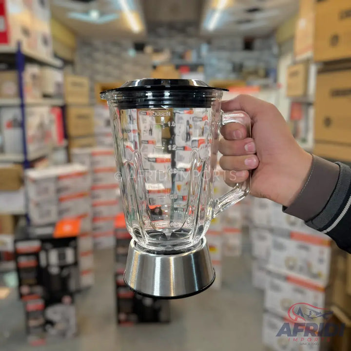 A clear glass blender jar with a black lid and a silver-toned base, featuring measurement markings on its side.