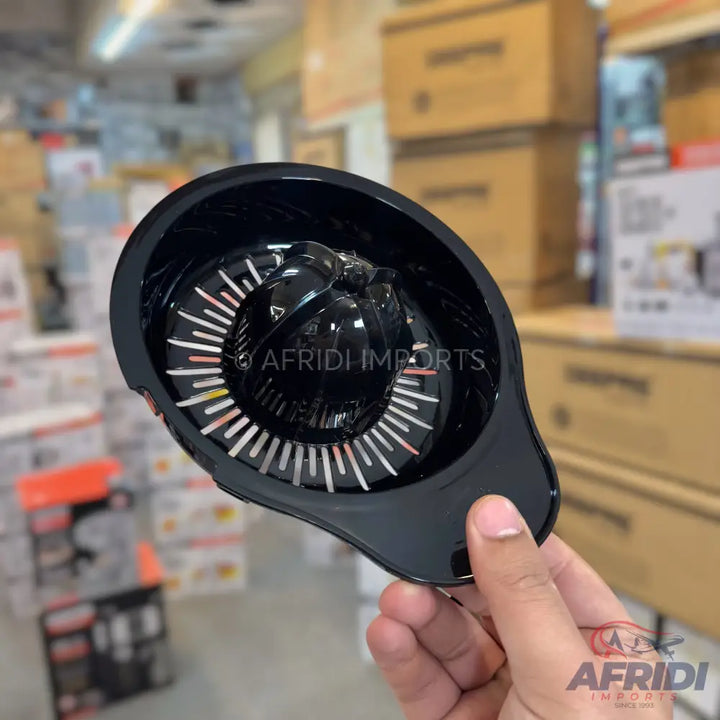 A black plastic citrus juicer attachment with a reamer and strainer, designed for extracting juice from fruit.