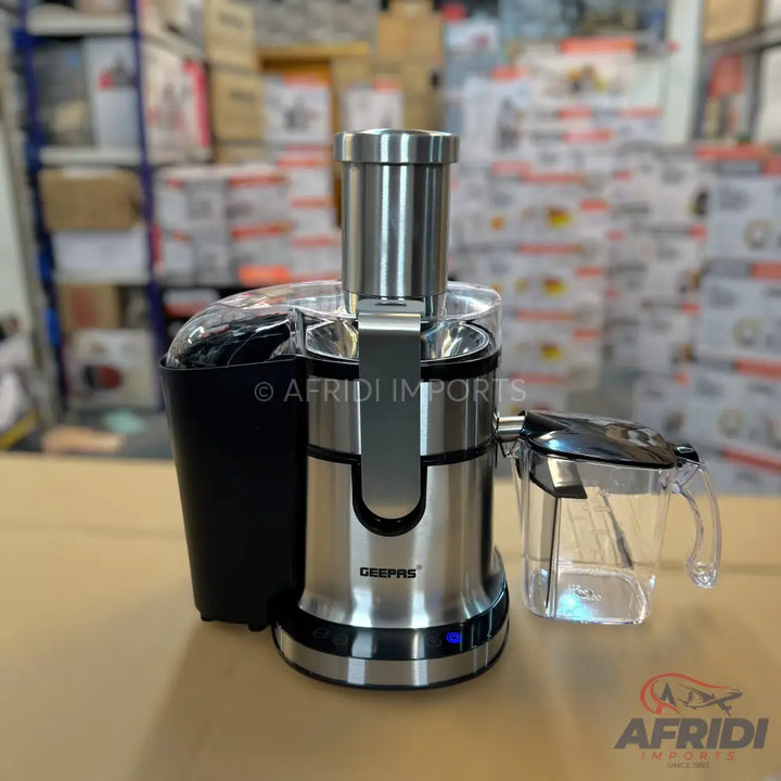 A stainless steel and black electric juicer with a clear pitcher.