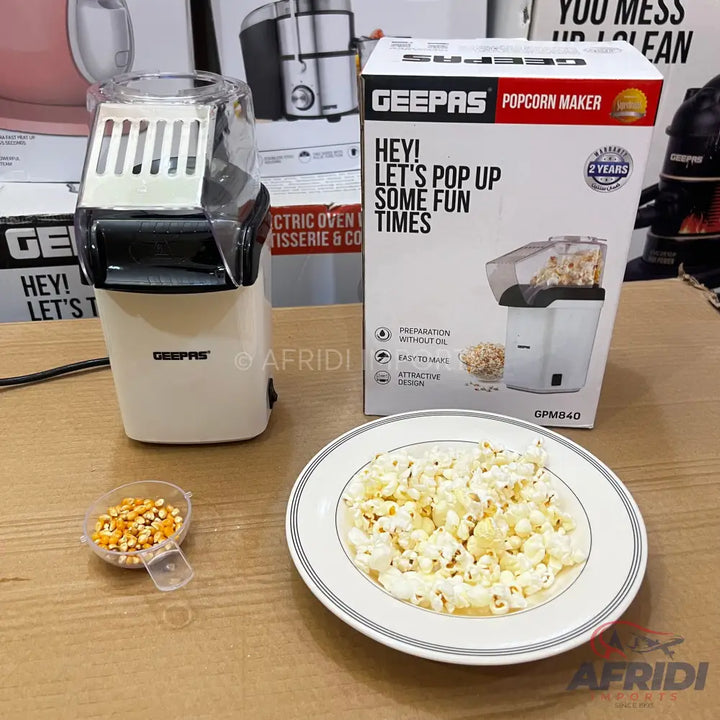 A white electric popcorn maker with a transparent top.