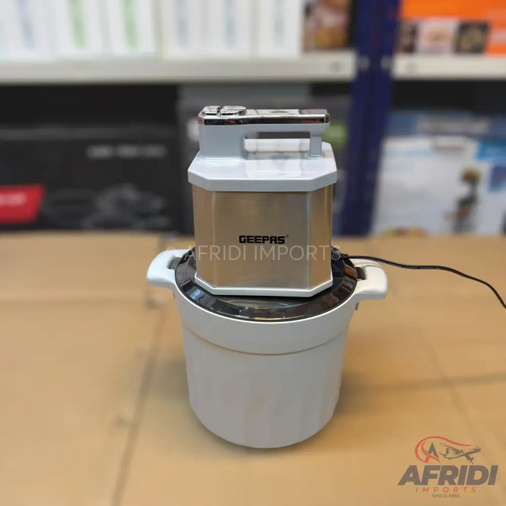 A white and gold electric food chopper or grinder with a power cord.