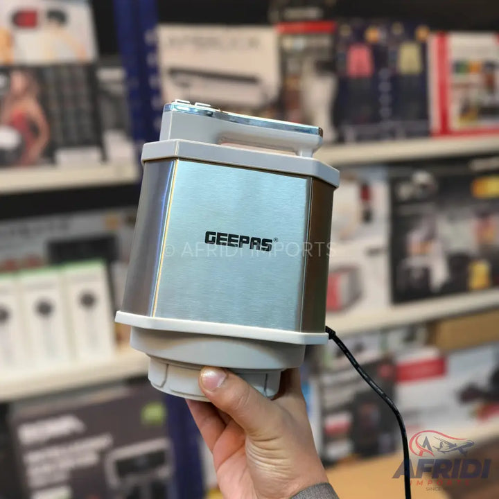 Silver and white electric coffee grinder with a black power cord.
