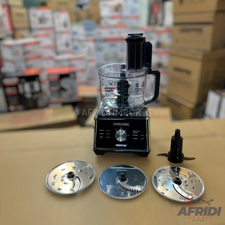 Black food processor with a clear bowl and multiple attachments.