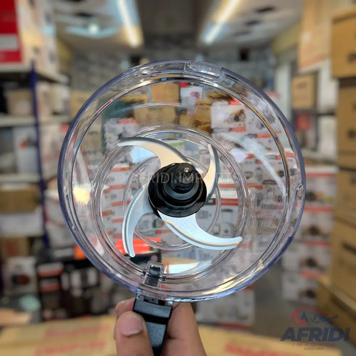 Clear plastic food chopper lid with three sharp blades.