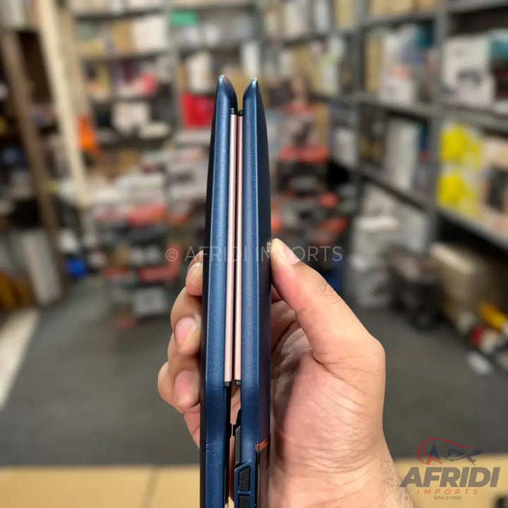 A blue and rose gold hair straightener held in a hand.