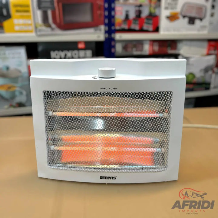 A white electric room heater with glowing orange heating elements behind a metal mesh.