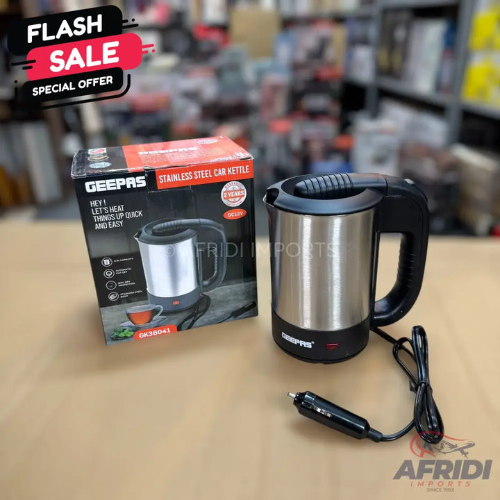 A stainless steel car kettle with a black handle and a cigarette lighter plug.