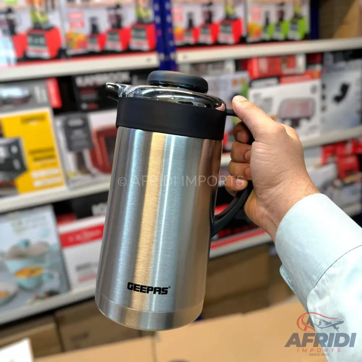 Stainless steel thermal carafe with a black handle and lid.