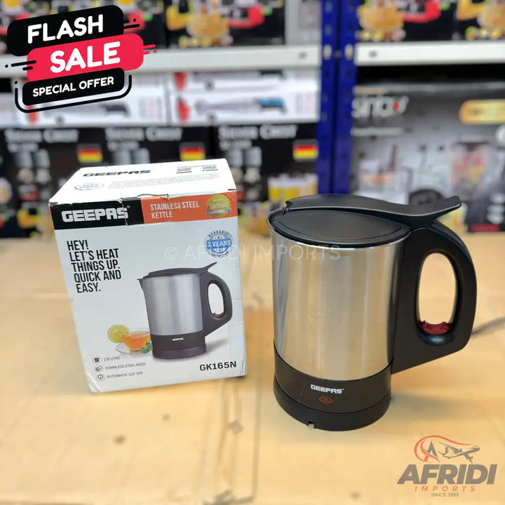 A stainless steel electric kettle with a black base and handle.