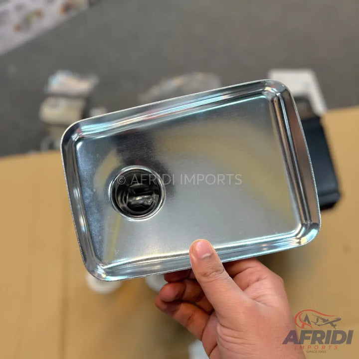 Shiny rectangular stainless steel tray with a circular opening.