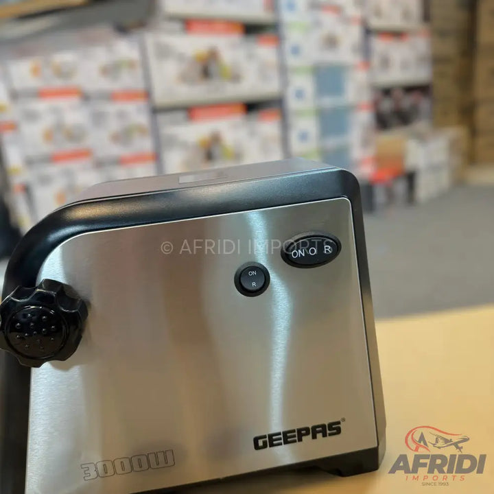 Stainless steel electric meat grinder with black trim.