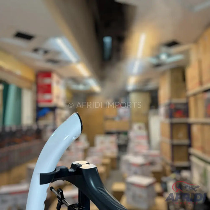 White and black handheld garment steamer.