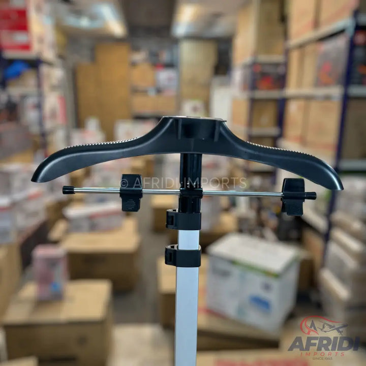 Black and silver garment steamer with a hanger and clips.