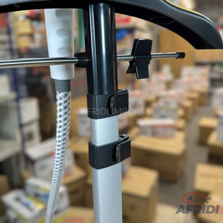 A silver and black garment steamer pole with a flexible hose and hanger attachment.