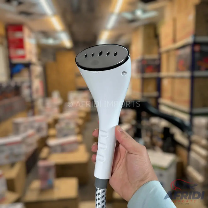 White handheld garment steamer with a metallic steaming plate.