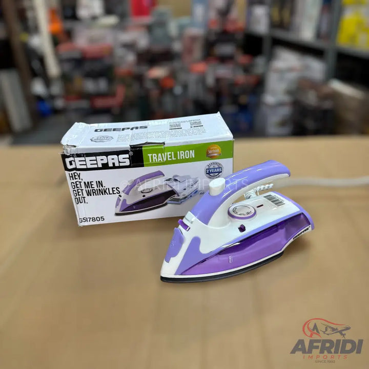 A purple and white travel iron with its product box.