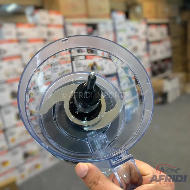 A clear plastic food processor bowl with a two-blade attachment.