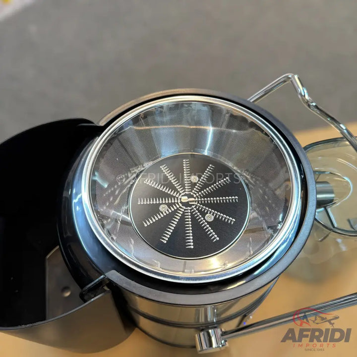 A stainless steel centrifugal juicer with a clear lid and a grater disc.