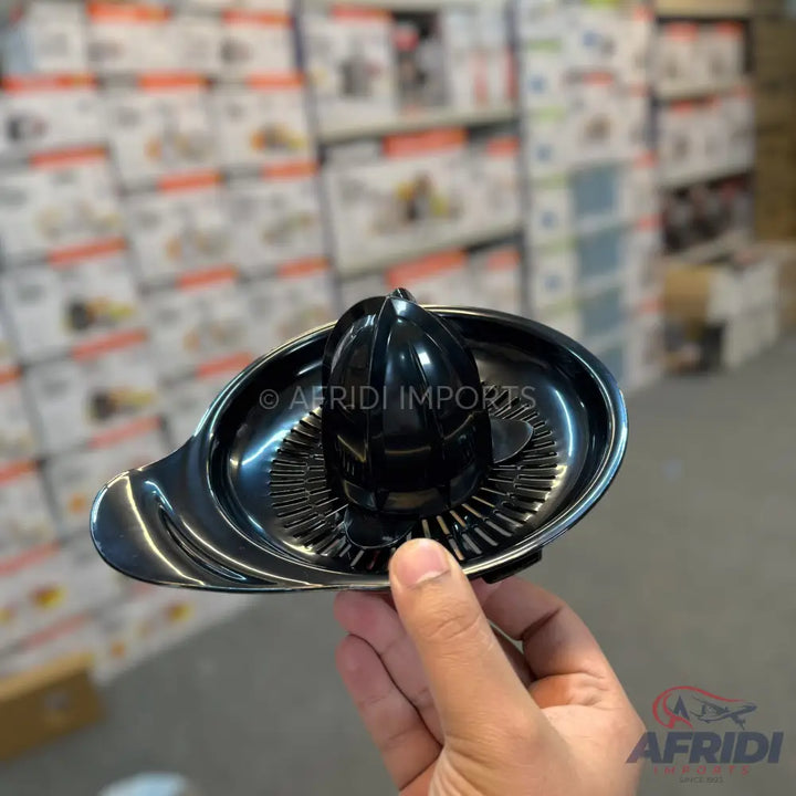 Black handheld citrus juicer.