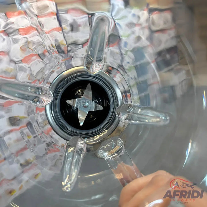 A clear blender jar with a four-pronged blade at the bottom.