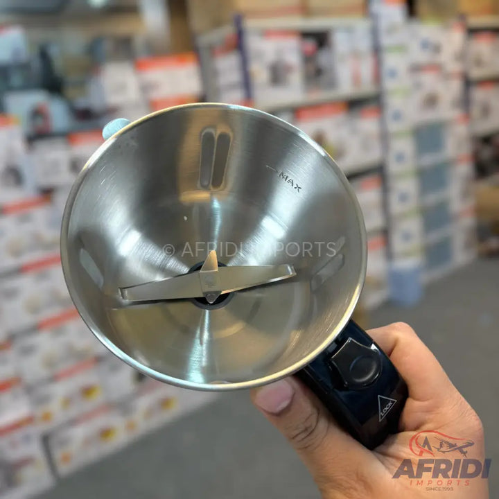 A stainless steel electric spice grinder with a two-pronged blade and a black handle featuring a power button.