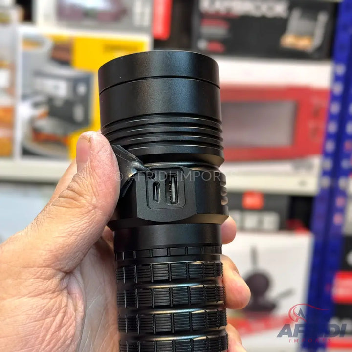 A black flashlight with USB-A and USB-C ports.