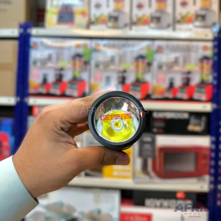 A black flashlight with a yellow LED in its head.