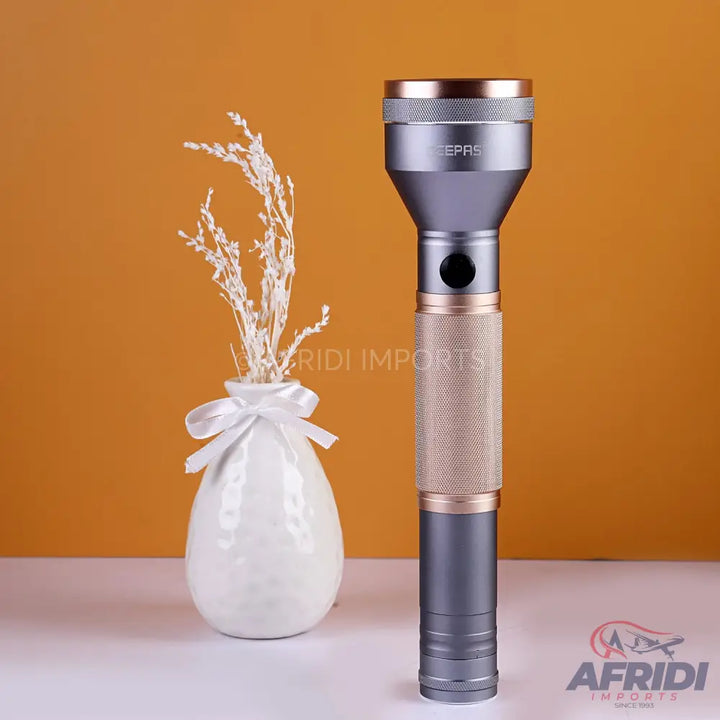 Gray and gold metallic flashlight with a textured grip.