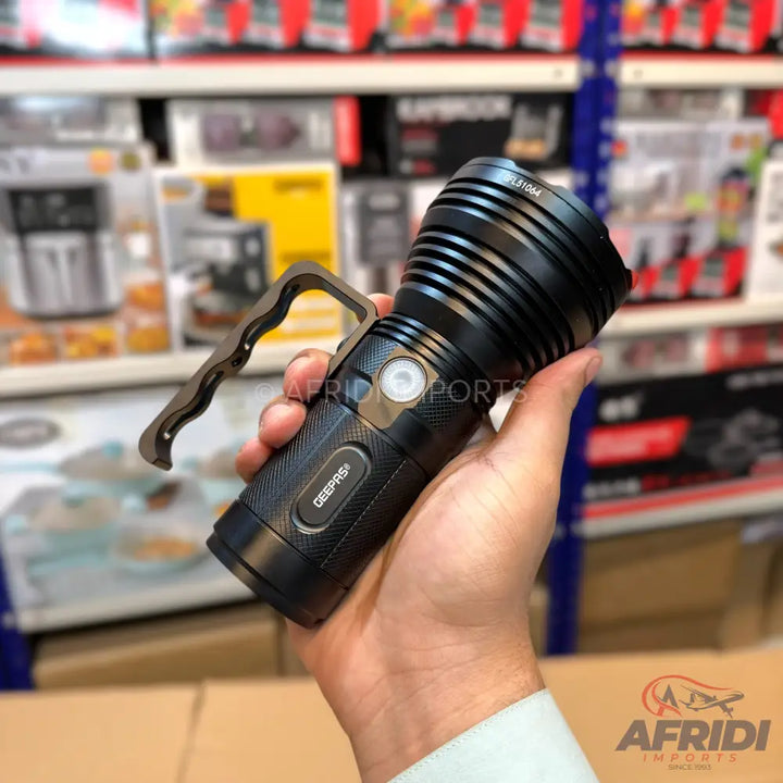 Black flashlight with a side handle.