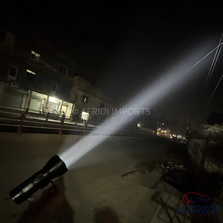 Black flashlight emitting a powerful beam of light.
