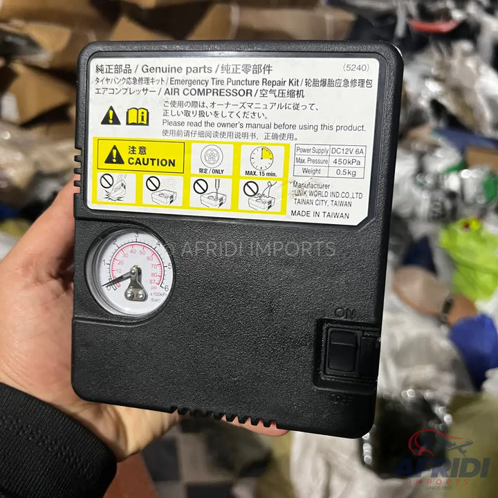 Black rectangular tire repair kit with an air compressor and pressure gauge.