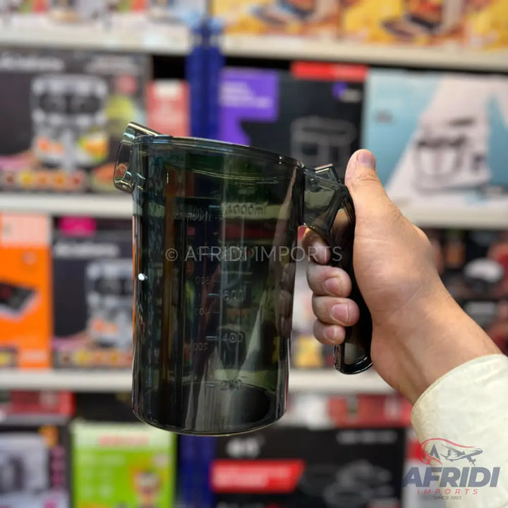 Dark gray plastic measuring cup with a handle.