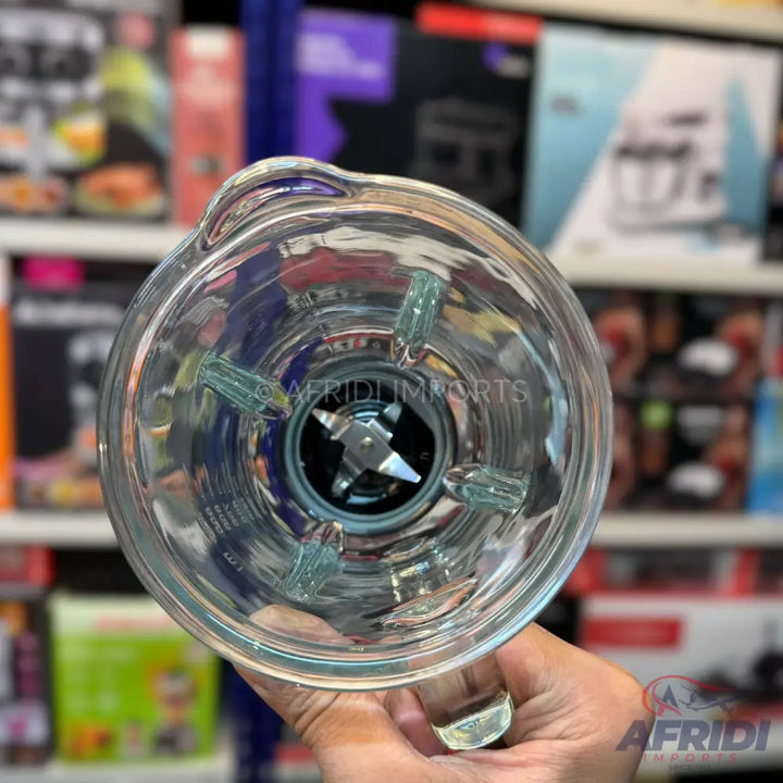 A transparent glass blender jar with an integrated four-blade assembly.