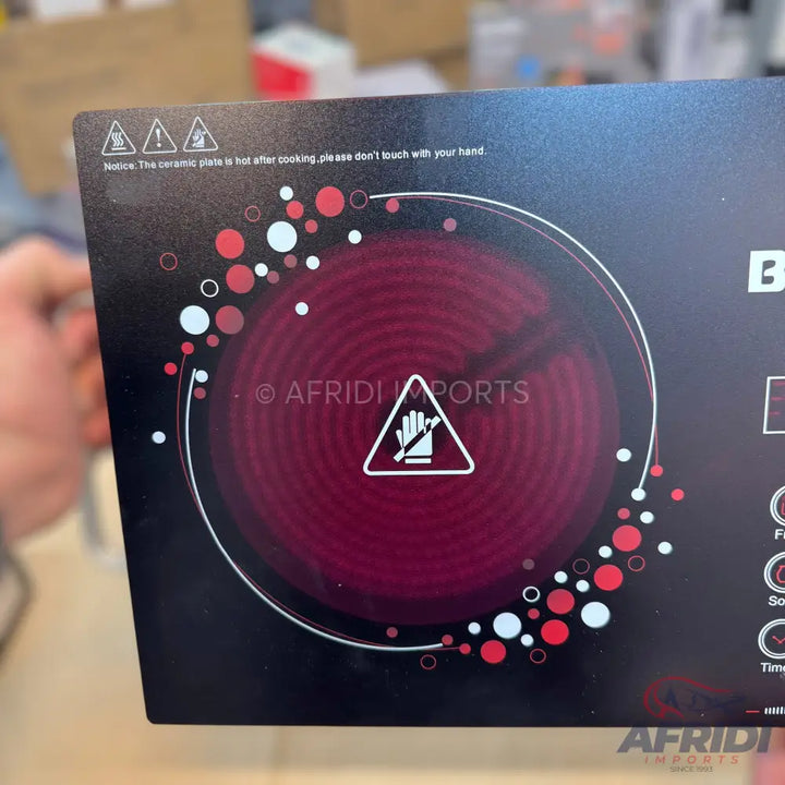 Black electric cooktop with a single red heating element.