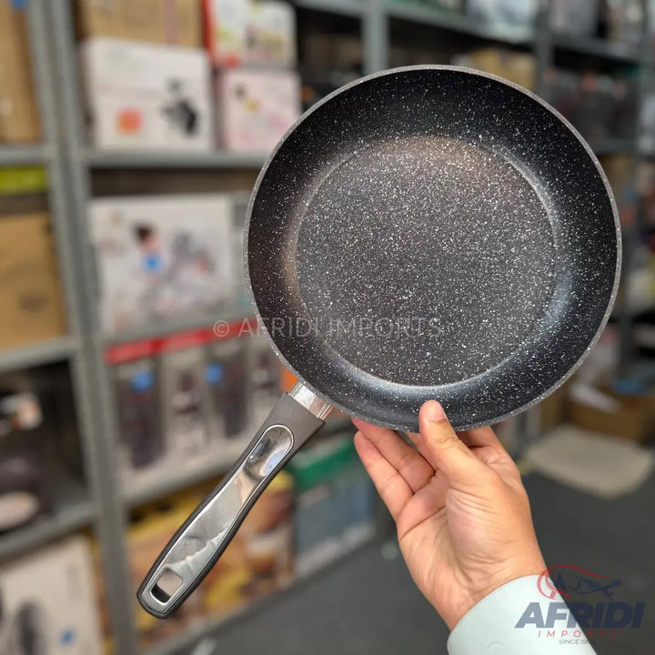 A black non-stick frying pan with a speckled interior and a silver and black handle.