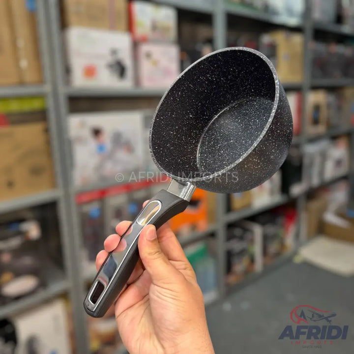 A dark gray, speckled saucepan with a black and silver handle.