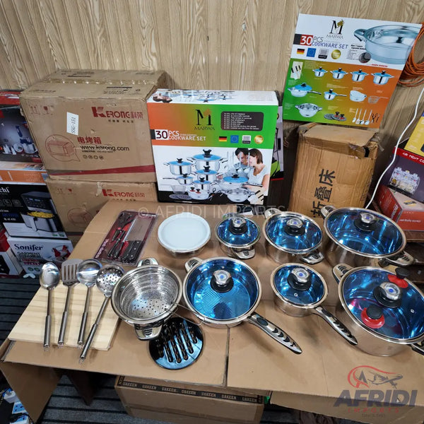 A 30-piece stainless steel cookware set with blue-tinted glass lids.