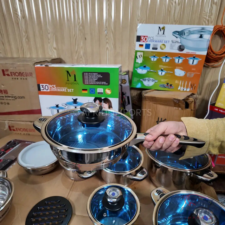 Stainless steel cookware set with blue glass lids.